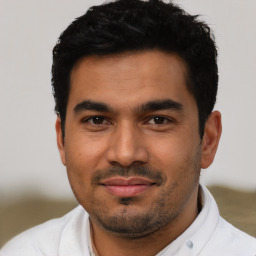 Joyful latino young-adult male with short  black hair and brown eyes