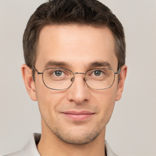 Joyful white young-adult male with short  brown hair and grey eyes