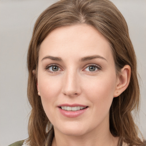 Joyful white young-adult female with medium  brown hair and grey eyes