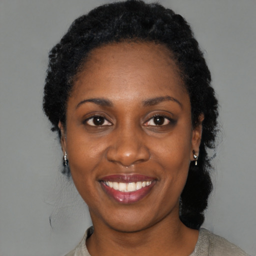Joyful black young-adult female with short  black hair and brown eyes