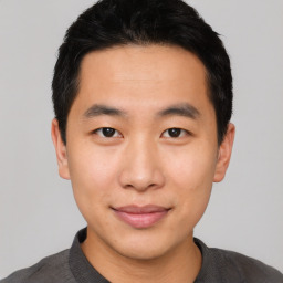 Joyful asian young-adult male with short  black hair and brown eyes