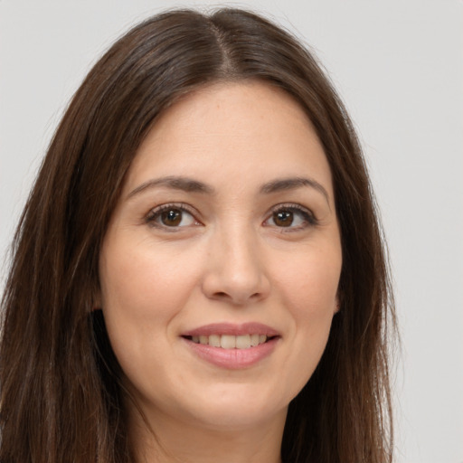 Joyful white young-adult female with long  brown hair and brown eyes