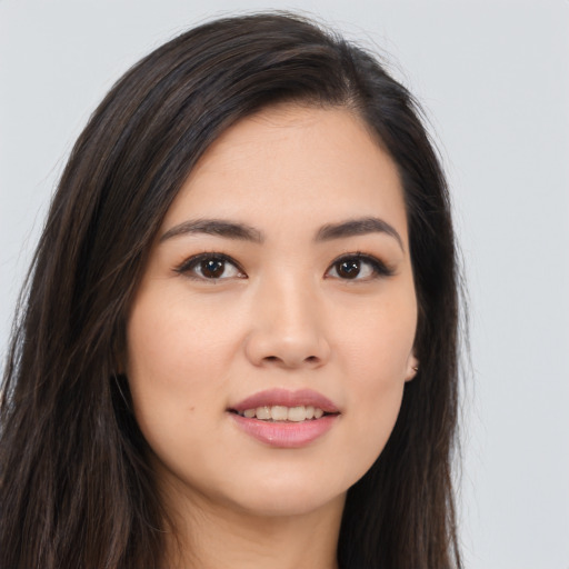 Joyful asian young-adult female with long  brown hair and brown eyes