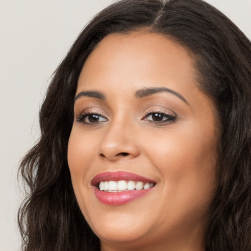 Joyful latino young-adult female with long  brown hair and brown eyes