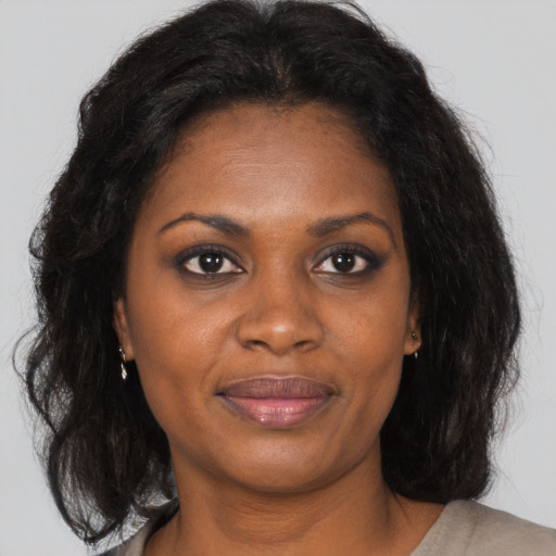 Joyful black adult female with medium  brown hair and brown eyes