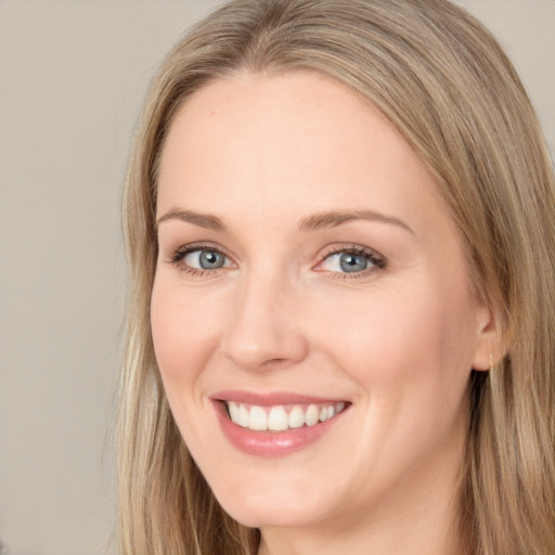 Joyful white young-adult female with long  brown hair and blue eyes