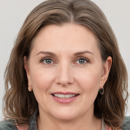 Joyful white adult female with medium  brown hair and grey eyes