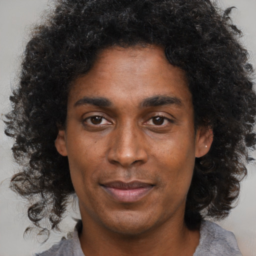 Joyful black young-adult male with medium  brown hair and brown eyes