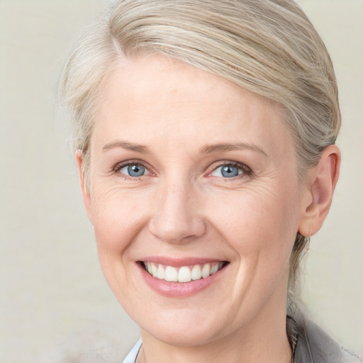 Joyful white adult female with medium  brown hair and blue eyes