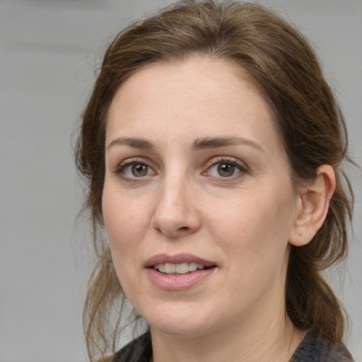 Joyful white young-adult female with medium  brown hair and grey eyes