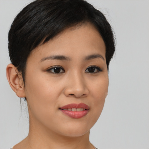 Joyful asian young-adult female with short  brown hair and brown eyes