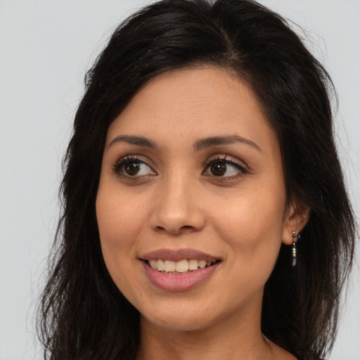 Joyful latino young-adult female with long  brown hair and brown eyes