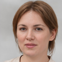 Joyful white young-adult female with medium  brown hair and grey eyes