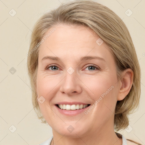 Joyful white young-adult female with medium  brown hair and blue eyes