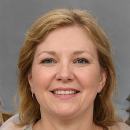 Joyful white adult female with medium  brown hair and blue eyes