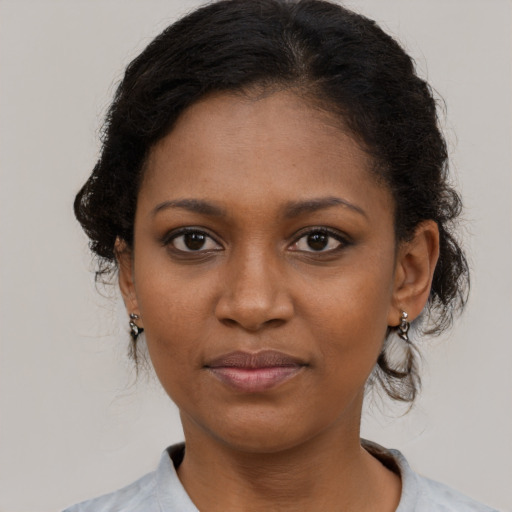Joyful black young-adult female with medium  brown hair and brown eyes