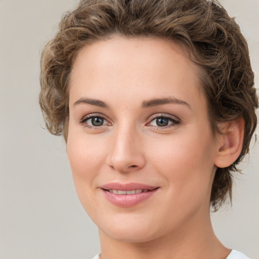 Joyful white young-adult female with medium  brown hair and green eyes