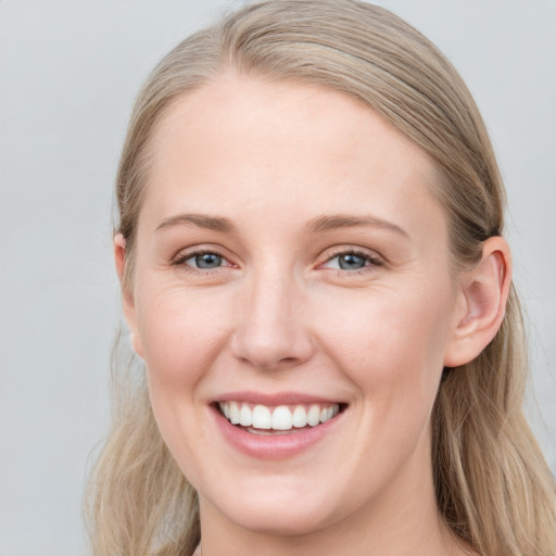 Joyful white young-adult female with long  brown hair and blue eyes