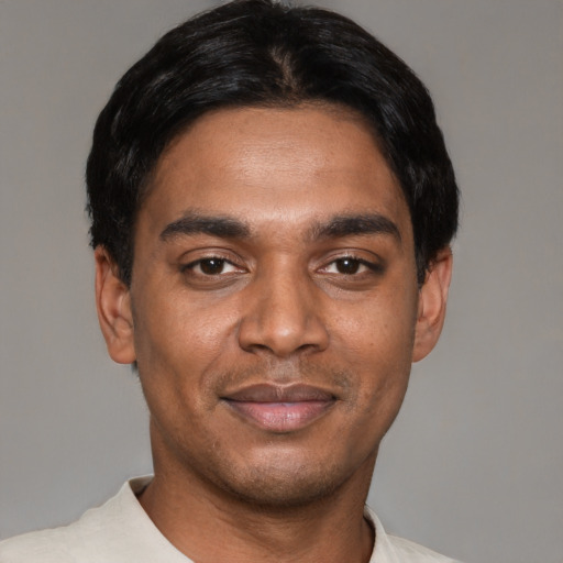 Joyful black young-adult male with short  black hair and brown eyes
