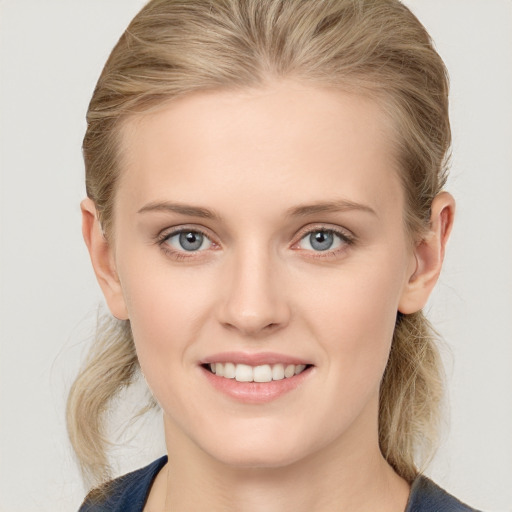 Joyful white young-adult female with medium  brown hair and blue eyes