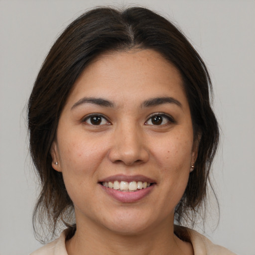 Joyful latino young-adult female with medium  brown hair and brown eyes
