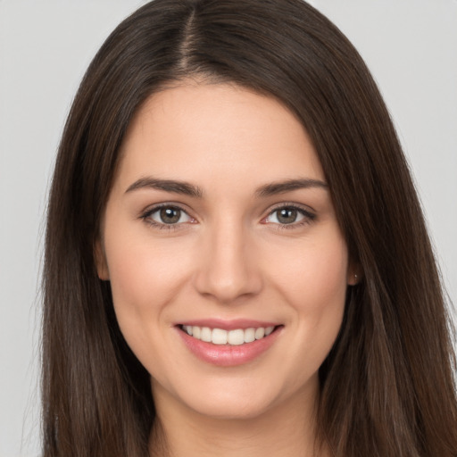 Joyful white young-adult female with long  brown hair and brown eyes