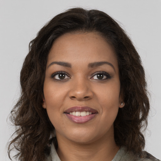 Joyful black young-adult female with long  brown hair and brown eyes