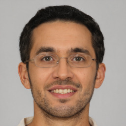 Joyful latino young-adult male with short  brown hair and brown eyes