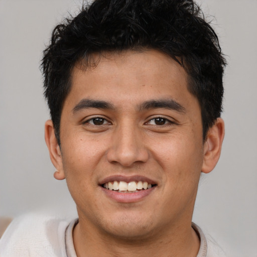 Joyful latino young-adult male with short  brown hair and brown eyes