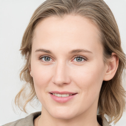 Joyful white young-adult female with medium  brown hair and blue eyes