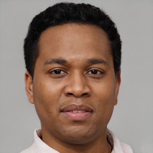 Joyful black adult male with short  black hair and brown eyes