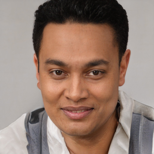 Joyful latino young-adult male with short  black hair and brown eyes