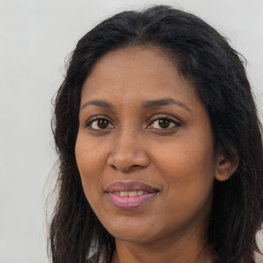 Joyful black adult female with long  brown hair and brown eyes