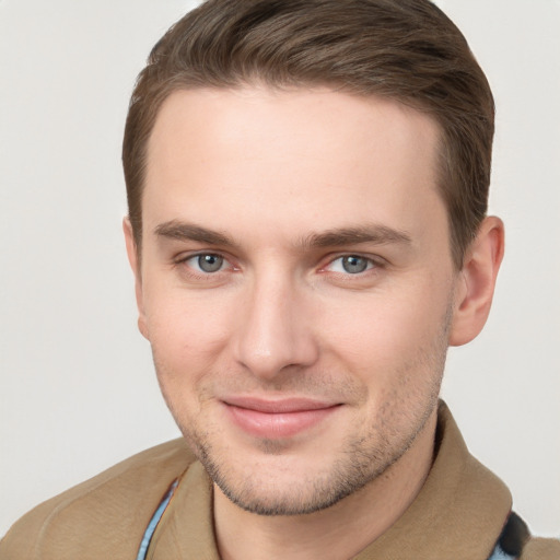 Joyful white young-adult male with short  brown hair and grey eyes