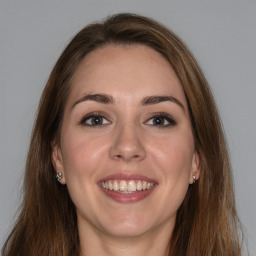 Joyful white young-adult female with long  brown hair and grey eyes