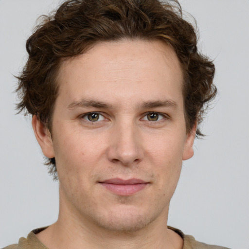 Joyful white young-adult male with short  brown hair and green eyes