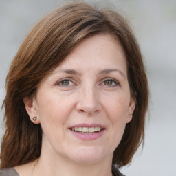 Joyful white adult female with medium  brown hair and grey eyes