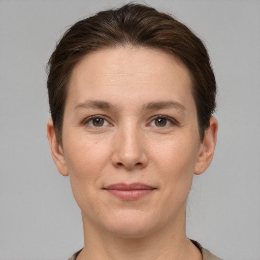 Joyful white young-adult female with short  brown hair and grey eyes