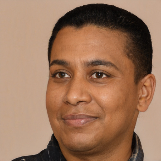 Joyful black adult male with short  black hair and brown eyes