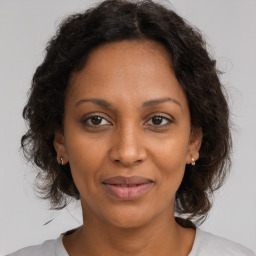 Joyful black adult female with medium  brown hair and brown eyes