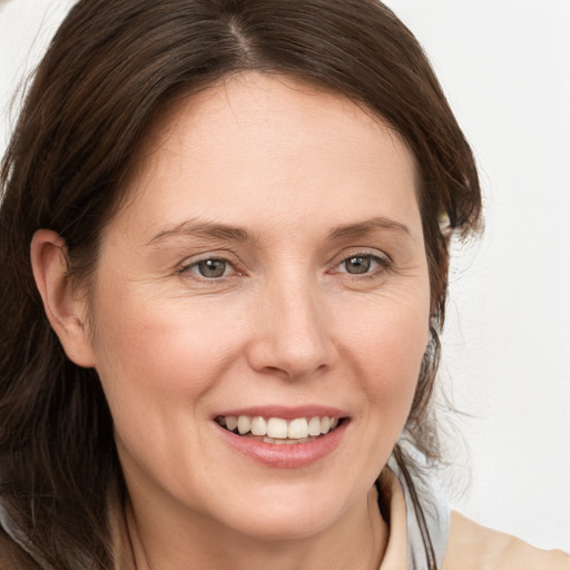 Joyful white adult female with medium  brown hair and grey eyes