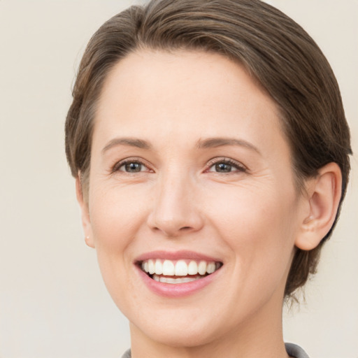 Joyful white young-adult female with short  brown hair and green eyes