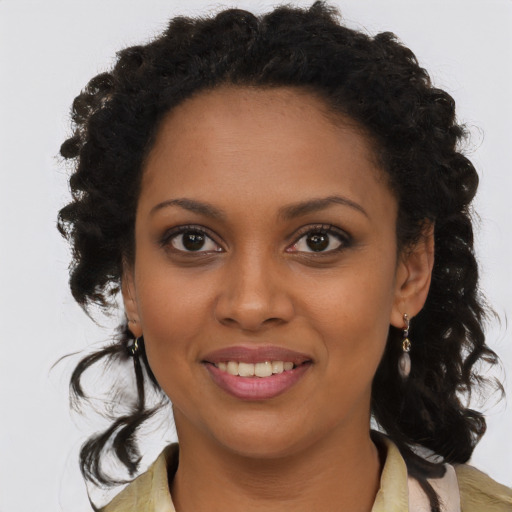 Joyful black young-adult female with long  brown hair and brown eyes