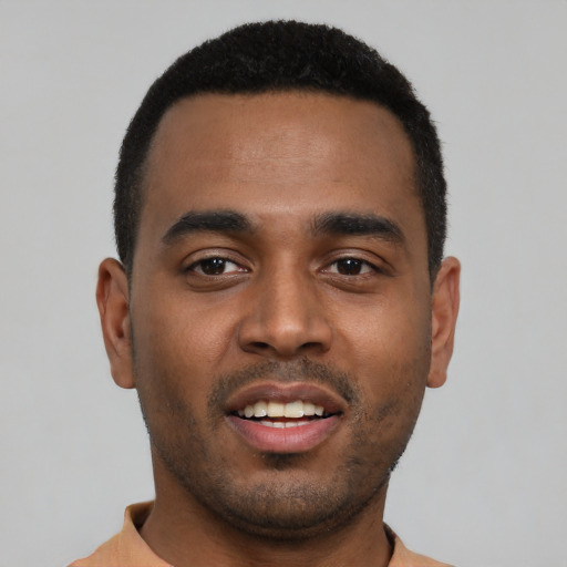 Joyful black young-adult male with short  black hair and brown eyes