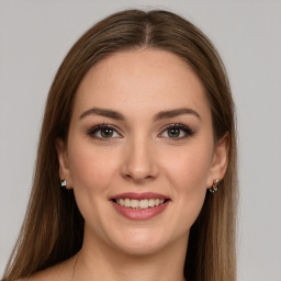 Joyful white young-adult female with long  brown hair and green eyes