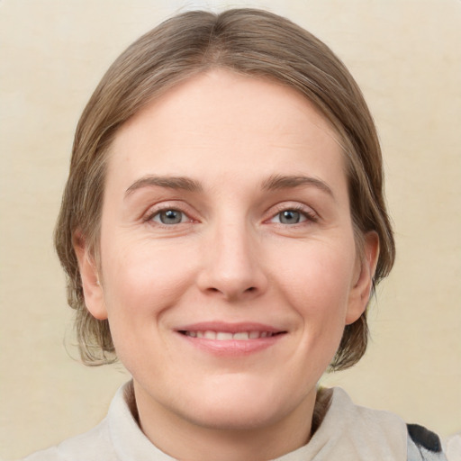 Joyful white young-adult female with medium  brown hair and grey eyes