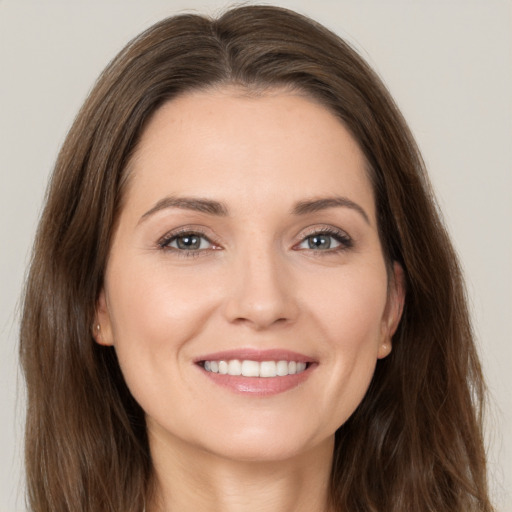 Joyful white young-adult female with long  brown hair and brown eyes