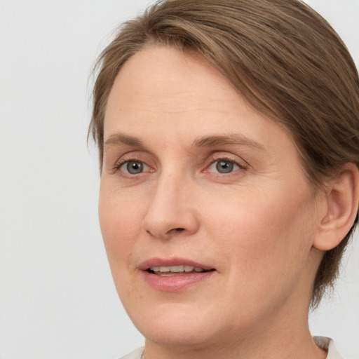 Joyful white adult female with medium  brown hair and green eyes