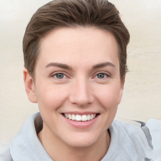 Joyful white young-adult female with short  brown hair and grey eyes