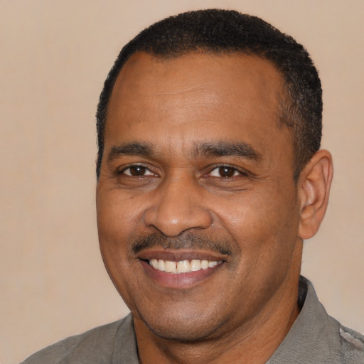 Joyful black adult male with short  black hair and brown eyes